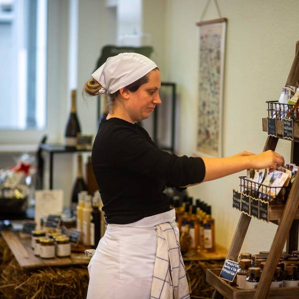 Das Bild zeigt Anika-Helena Wübben in ihrem Geschäft, wie sie ein Regal sortiert.