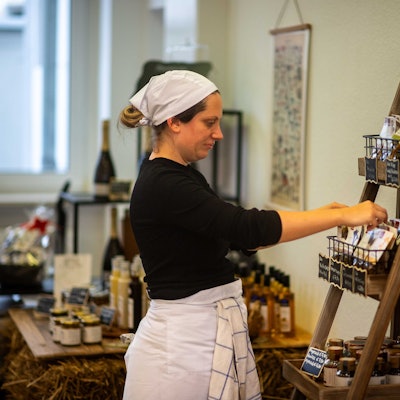 Das Bild zeigt Anika-Helena Wübben in ihrem Geschäft, wie sie ein Regal sortiert.