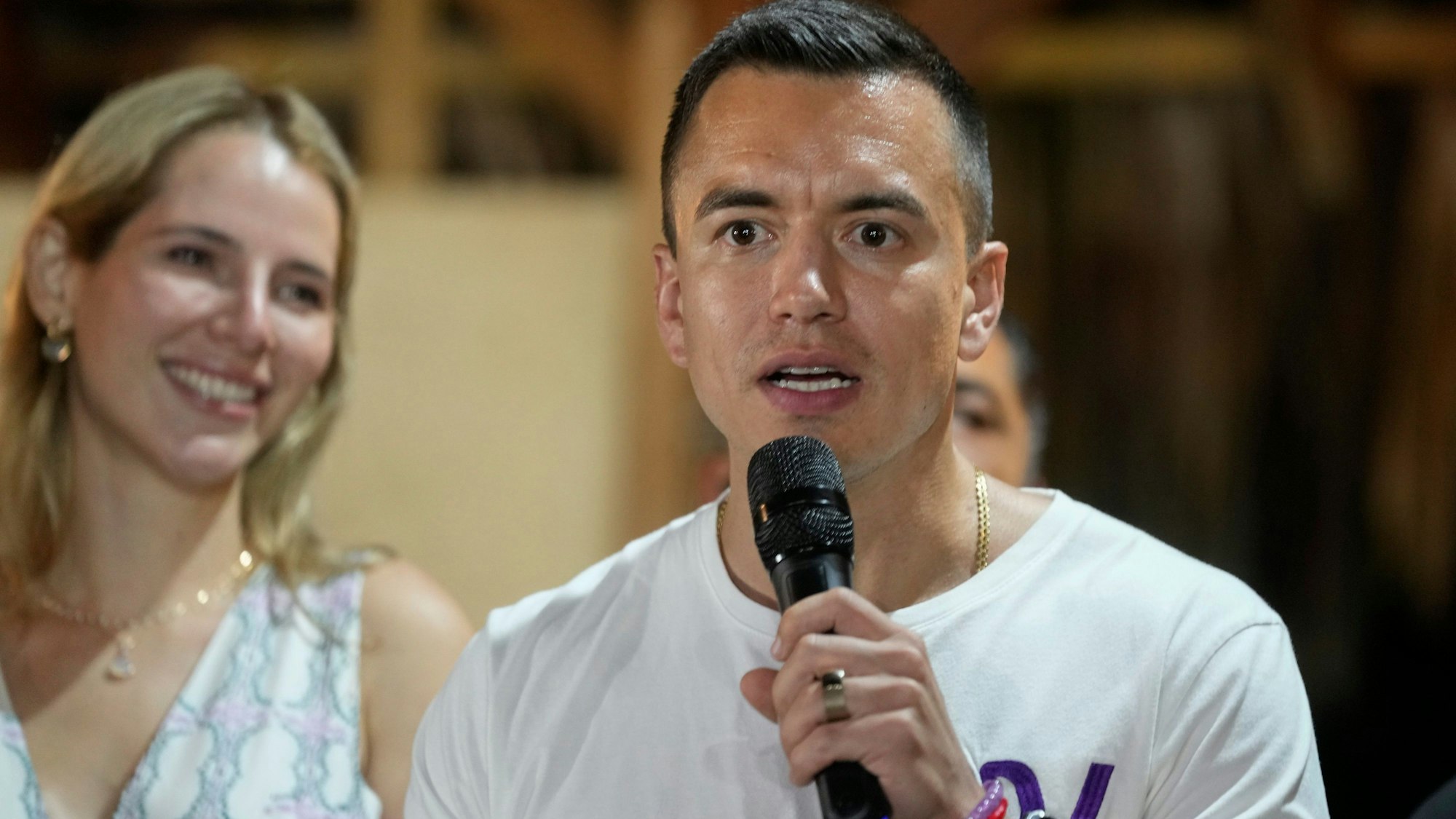 Presidential candidate Daniel Noboa speaks in Olon, Ecuador, after results show him ahead in a snap presidential runoff on Sunday, Oct. 15, 2023. At left is his wife Lavinia Valbonesi. (AP Photo/Martin Mejia)