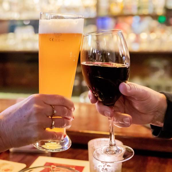 Ein Paar mit stößt mit Wein und Bier an.