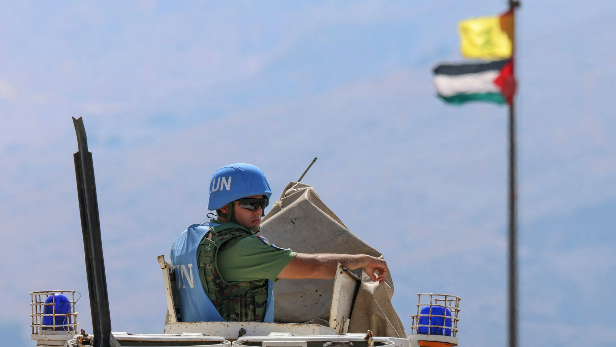 Die palästinensische Flagge und die Flagge der Hisbollah wehen im Wind, während Truppen der UN-Mission im Libanon (UNIFIL) im Grenzgebiet zwischen Libanon und Israel patrouillieren. Am Sonntag trag eine Rakete das Hauptquartier der Blauhelme.
