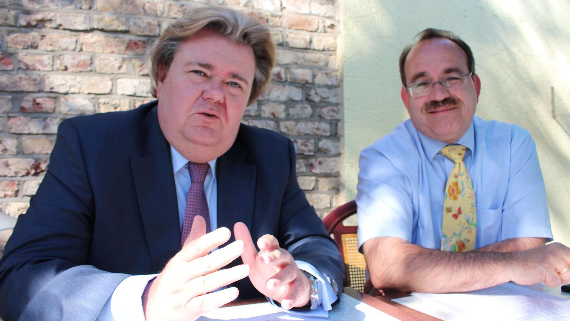 Die Landtagsabgeordneten Klaus Voussem und Dr. Ralf Nolten (beide CDU) sitzen bei einem Pressegespräch an einem Tisch.