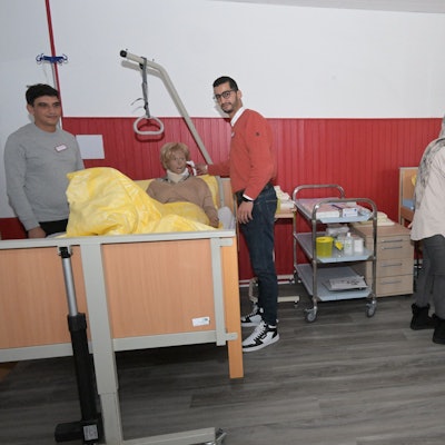 Angehende Pflegekräfte üben mit lebensgroßen Patientenpuppen in Pflegebetten ihren künftigen Berufsalltag.
