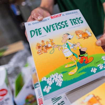 Ausgaben des neuen Asterix-Band Nummer 40 mit dem Titel „Die weiße Iris“ werden in einer Logistikhalle konfektioniert und in Displays für den Einzelhandel verpackt.