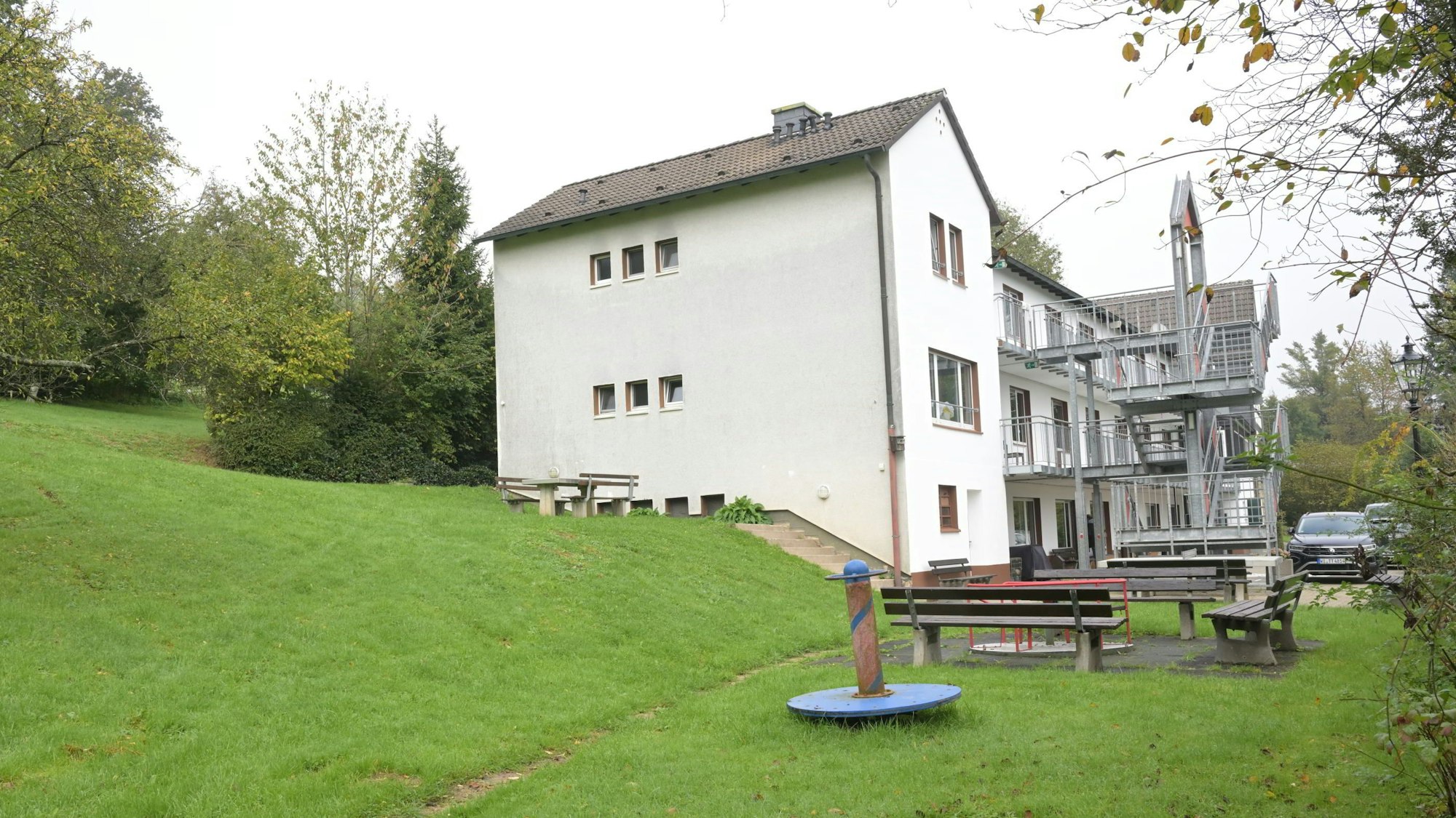 Vor und neben einem Tagungshaus ist viel Grün zu sehen.