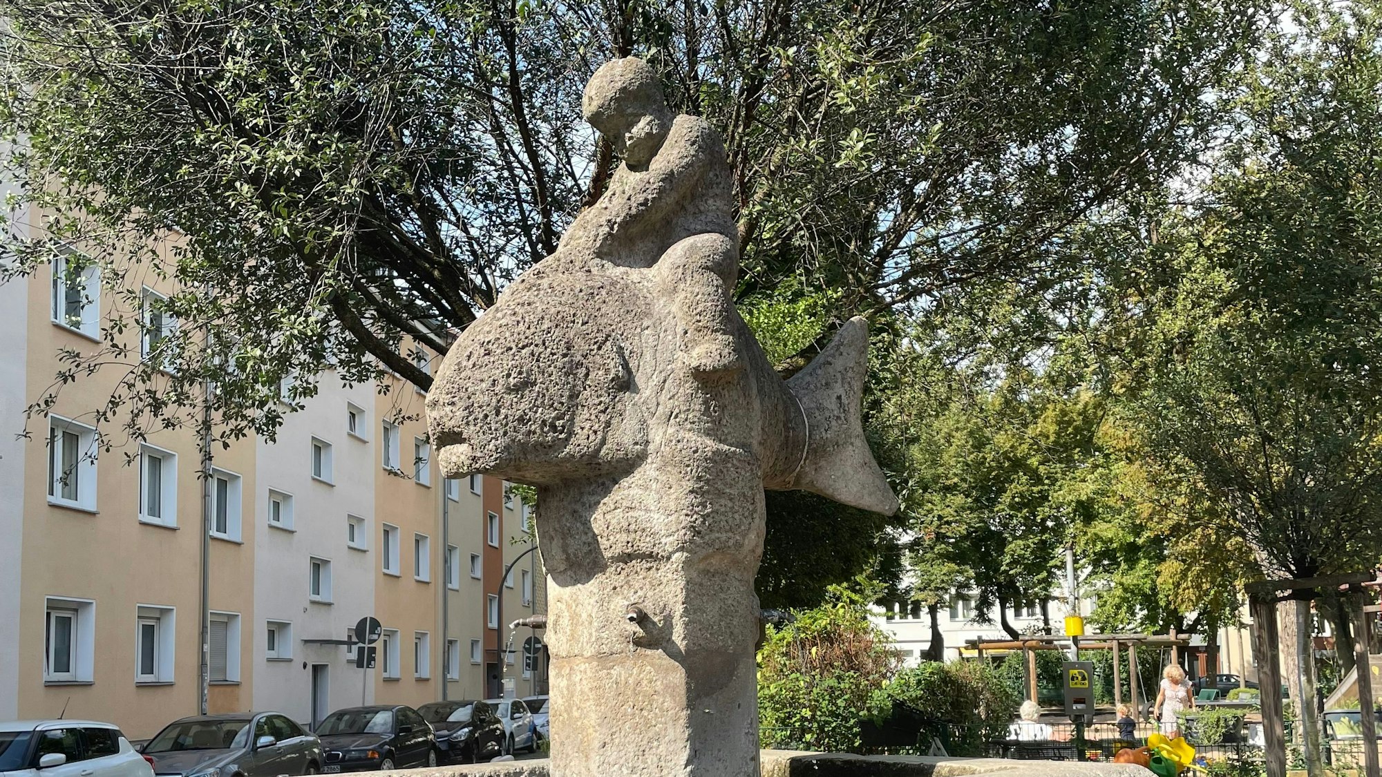 Ein Brunnen, der einen Jungen zeigt, der auf einem Fisch reitet.