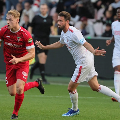 Fußballspieler stehen auf einem Fußballplatz.