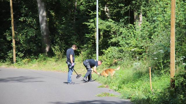 Ermittler an einem Waldstück.