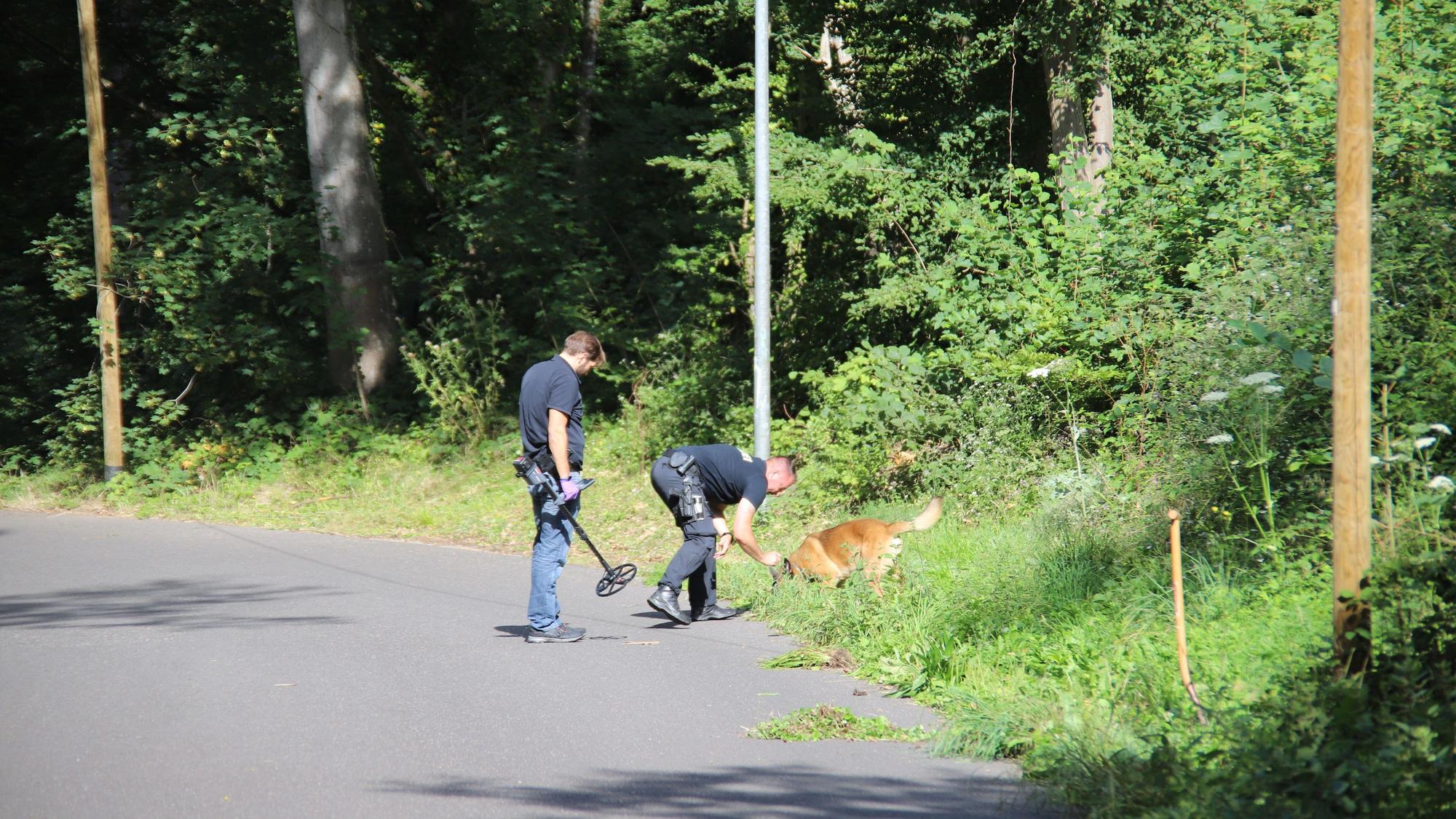 Ermittler an einem Waldstück.