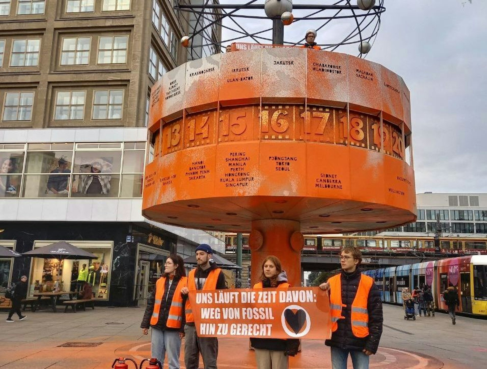Alexanderplatz in Berlin: Mitglieder der Letzten Generation haben die Weltzeituhr mit Farbe besprüht und ein Banner gezeigt.