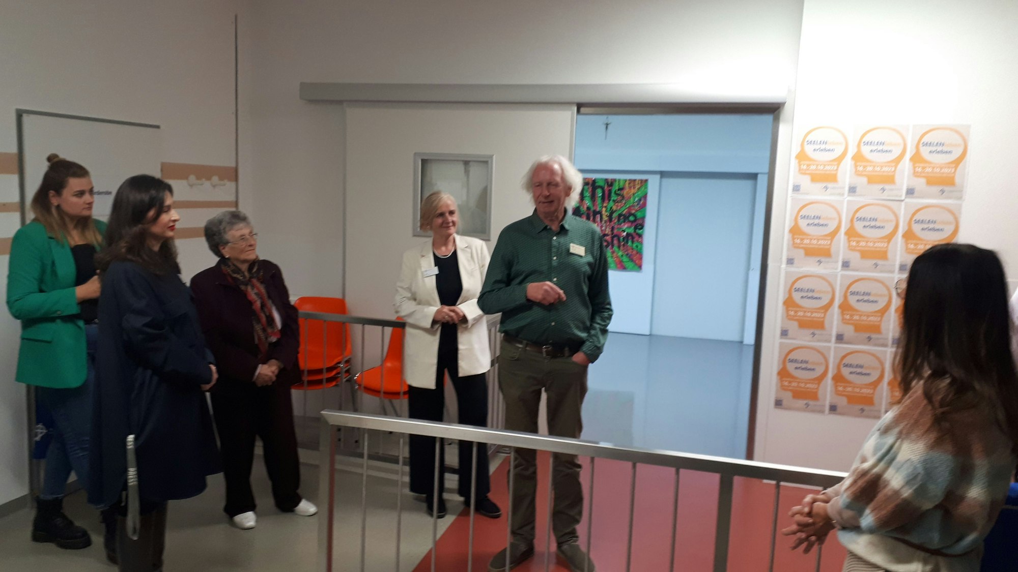 Einige Frauen und ein Mann stehen im Flur eines Krankenhauses.