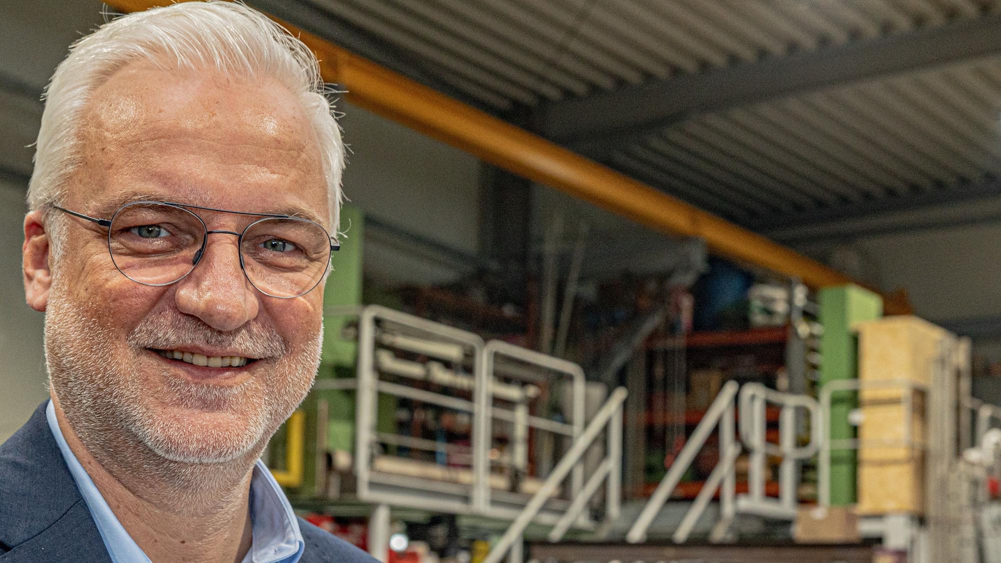 Garrelt Duin, der frühere Hauptgeschäftsführer der Handwerkskammer zu Köln, steht vor einer Industrieanlage.