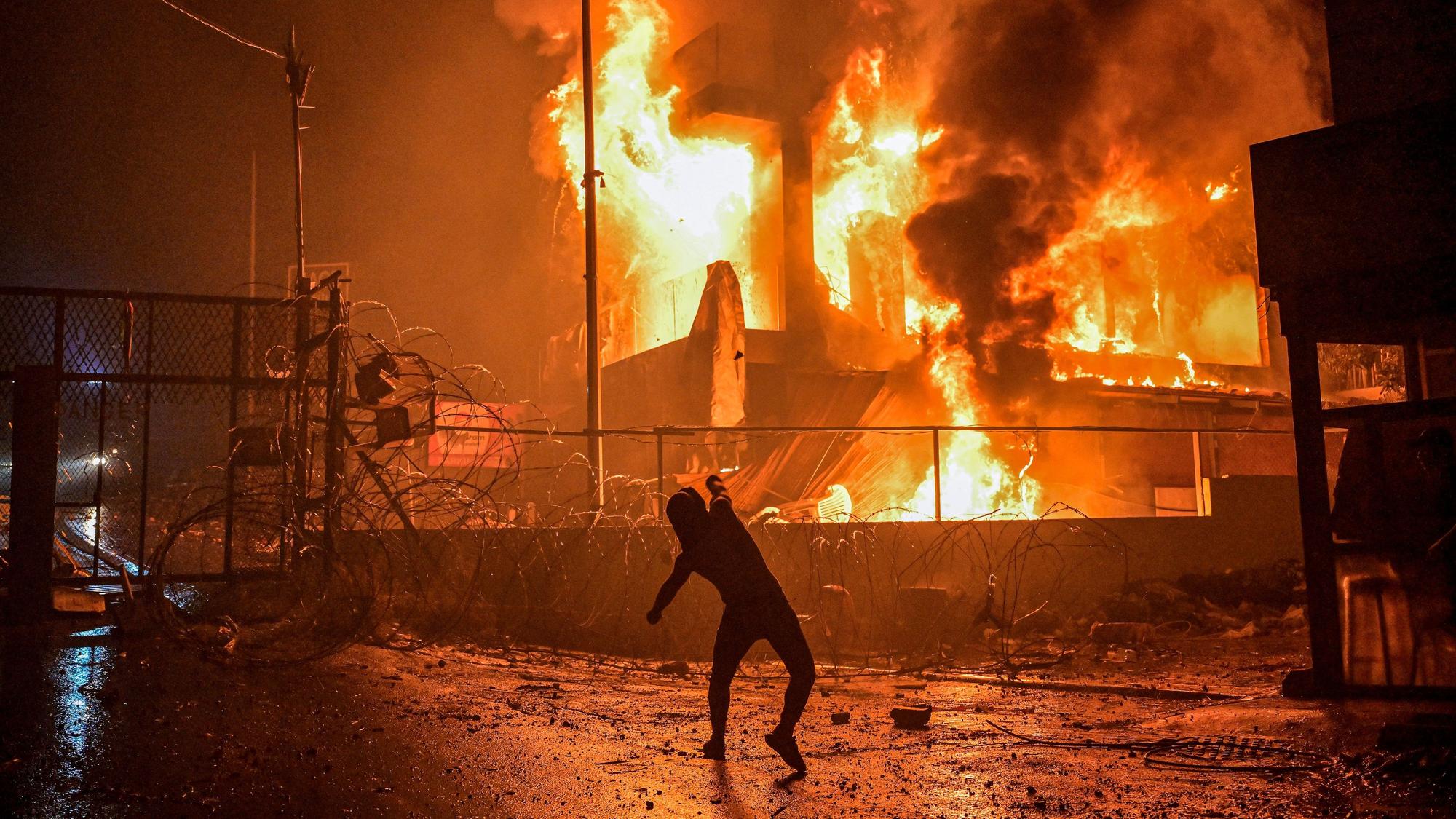 Ein libanesischer Demonstrant wirft Steine auf ein brennendes Gebäude in der Nähe der US-Botschaft während einer Solidaritätsdemonstration mit der Bevölkerung des Gazastreifens.