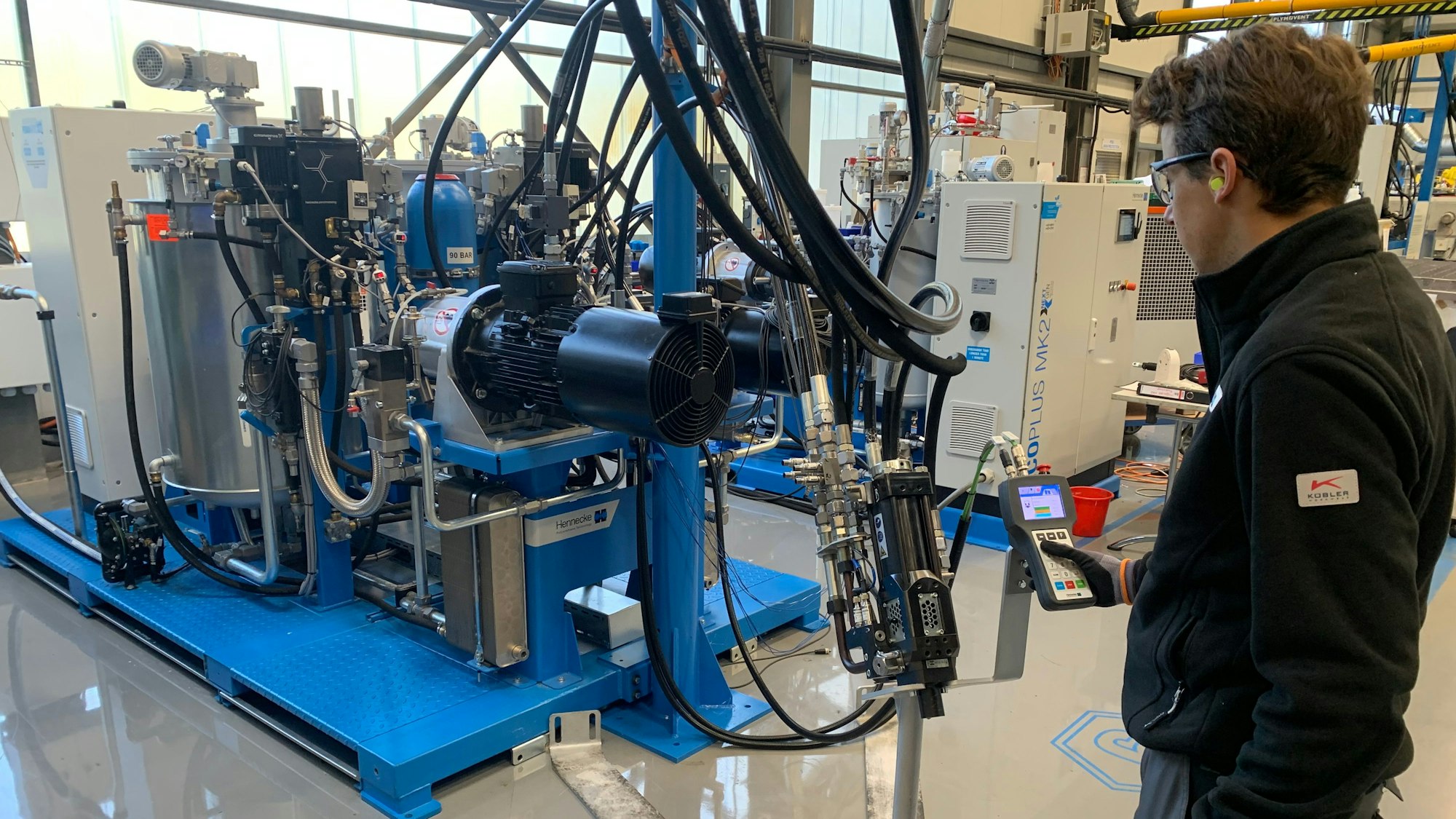 Ingenieur Marc Wendt an der neuen Hochdruck-Dosiermaschine MK2 von Hennecke.