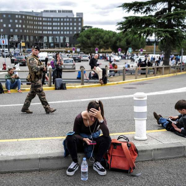 Evakuierung in Frankreich: Reisende warten, während ein französischer Soldat vor dem Flughafen Toulouse-Blagnac patrouilliert.