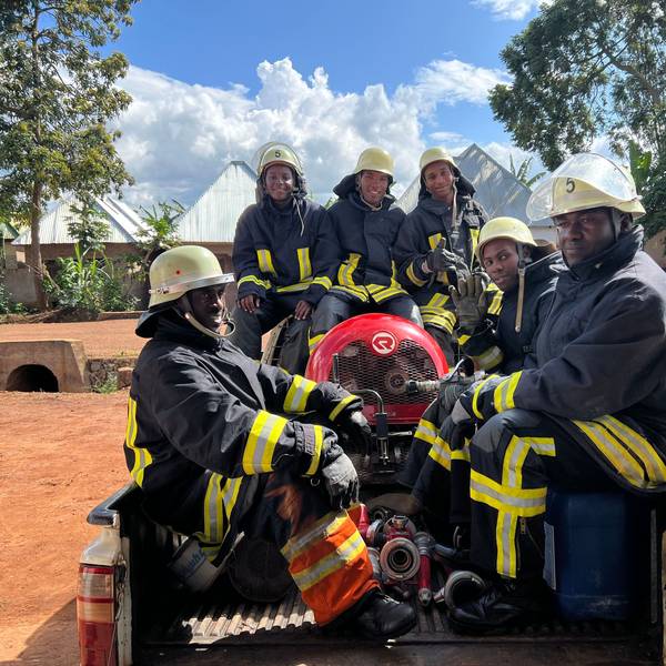 Foto von sechs Feuerwehrmännern mit Gerätschaften auf der Ladefläche eines Pick-ups.