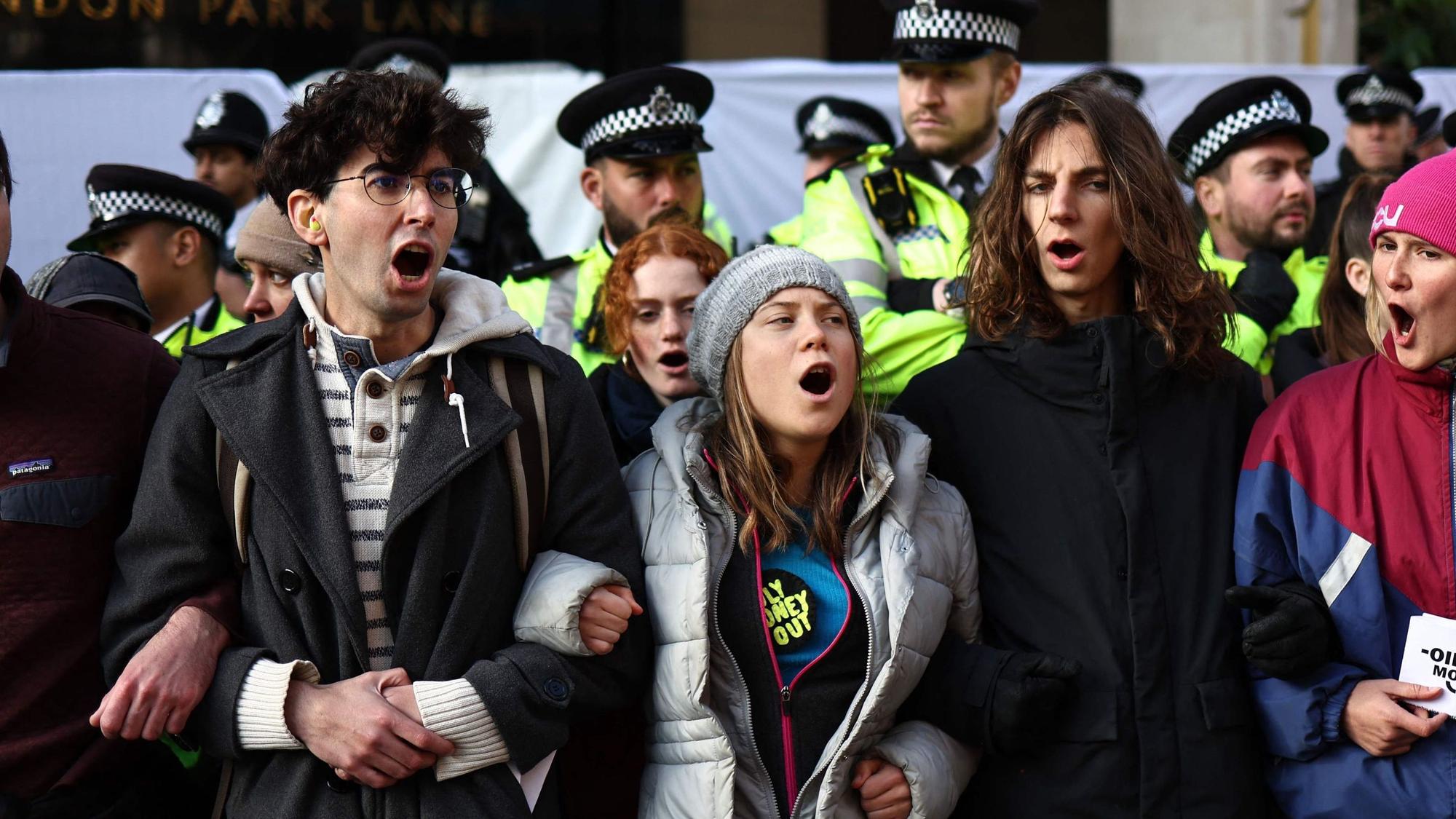 Swedish climate activist Greta Thunberg shouts slogans with fellow protesters outside the InterContinental London Park Lane during the "Oily Money Out" demonstration organised by Fossil Free London and Greenpeace on the sidelines of the opening day of the Energy Intelligence Forum 2023 in London on October 17, 2023. (Photo by HENRY NICHOLLS / AFP)