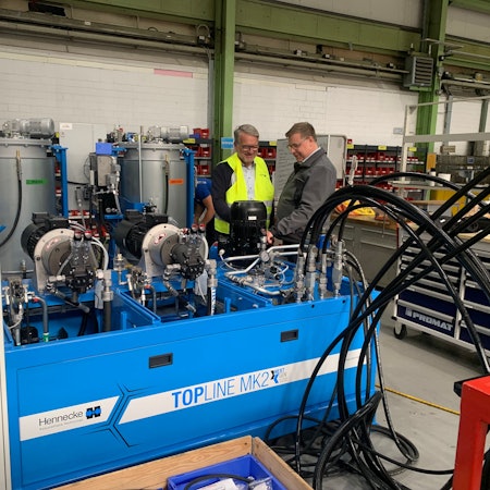 Zwei Männer an einer Maschine.