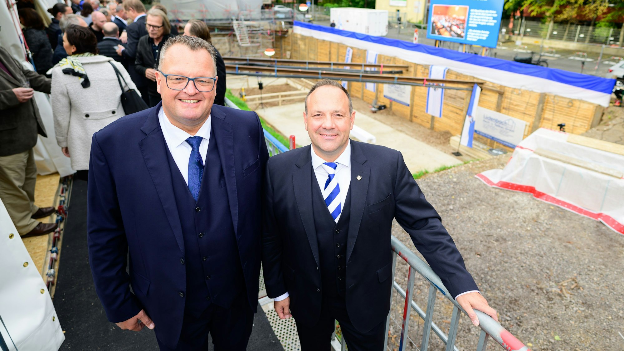 Zwei Männer stehen vor einer Baugrube.