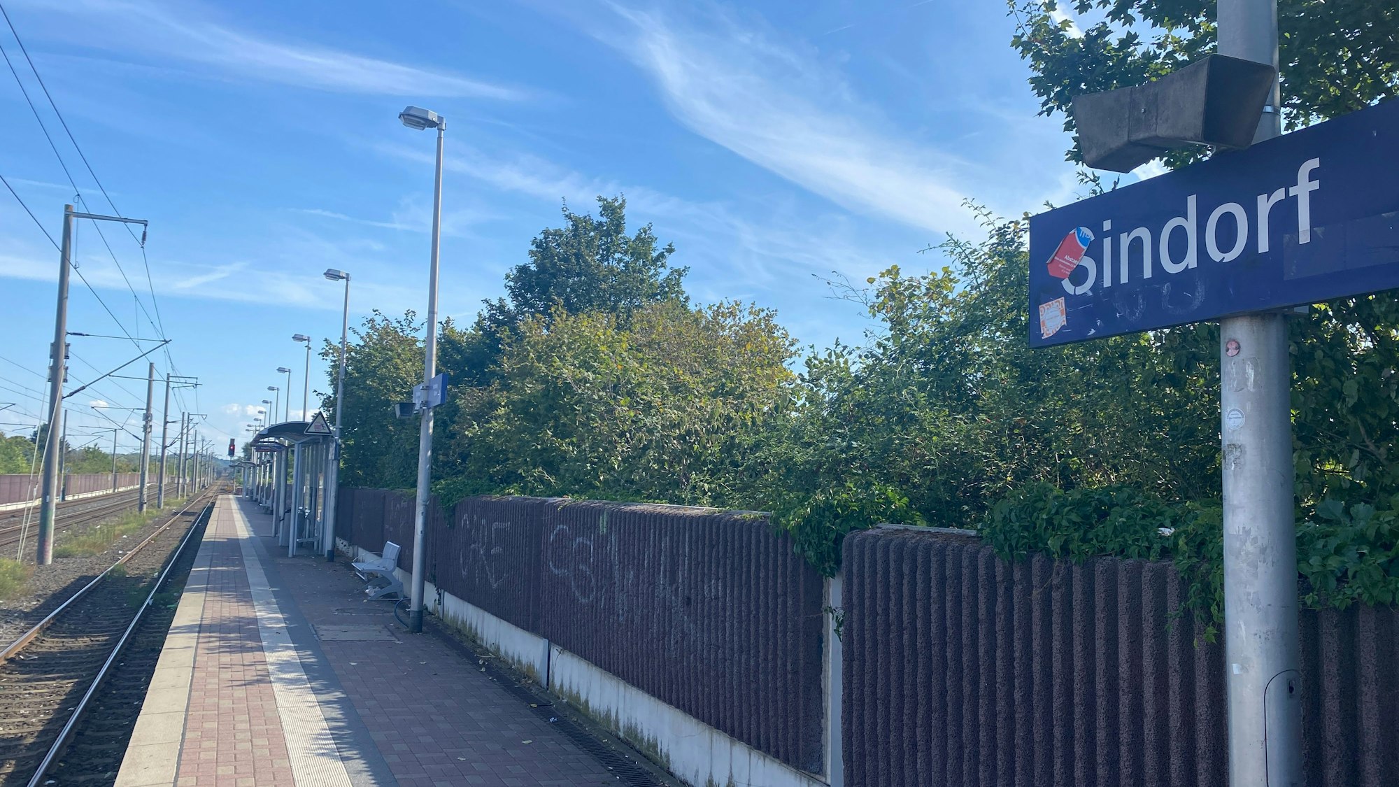 Die Bahnstation in Sindorf. An einer Schallschutzmauer ist Graffiti.