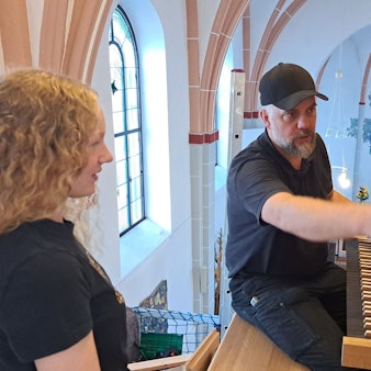 Das Bild zeigt Orgelbauer Martin Hiltmann und die Schülerin Fenja vor der Entdeckerorgel