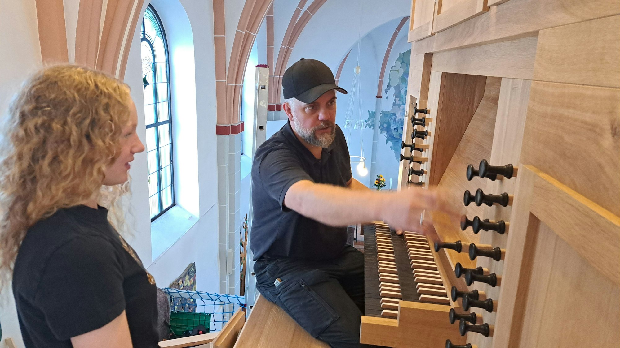 Das Bild zeigt Orgelbauer Martin Hiltmann und die Schülerin Fenja vor der Entdeckerorgel