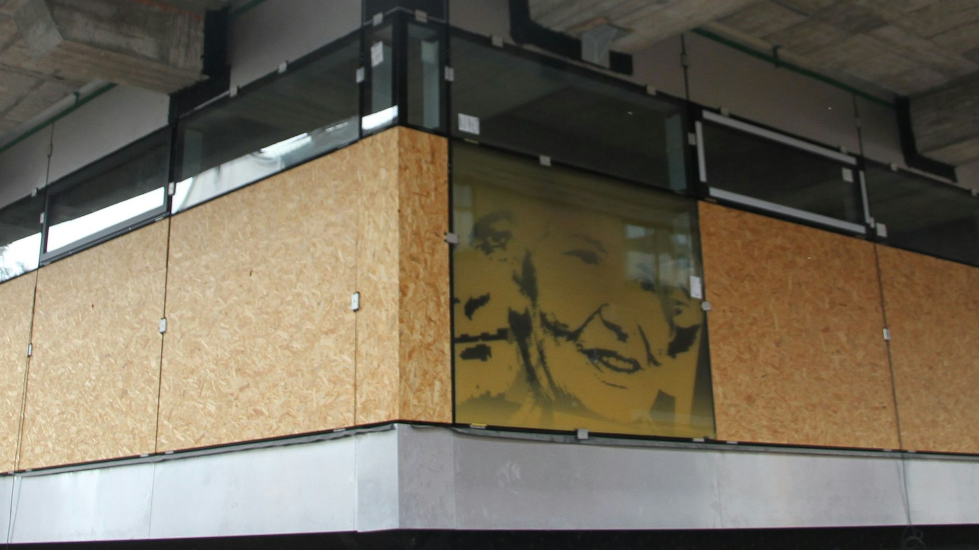 Eine gelbe Fensterscheibe an der Fassade des Rathauses zeigt ein Porträt der Schriftstellerin Ruth Rehmann