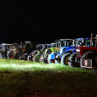 Mehrere Traktoren stehen nebeneinander auf einer Wiese