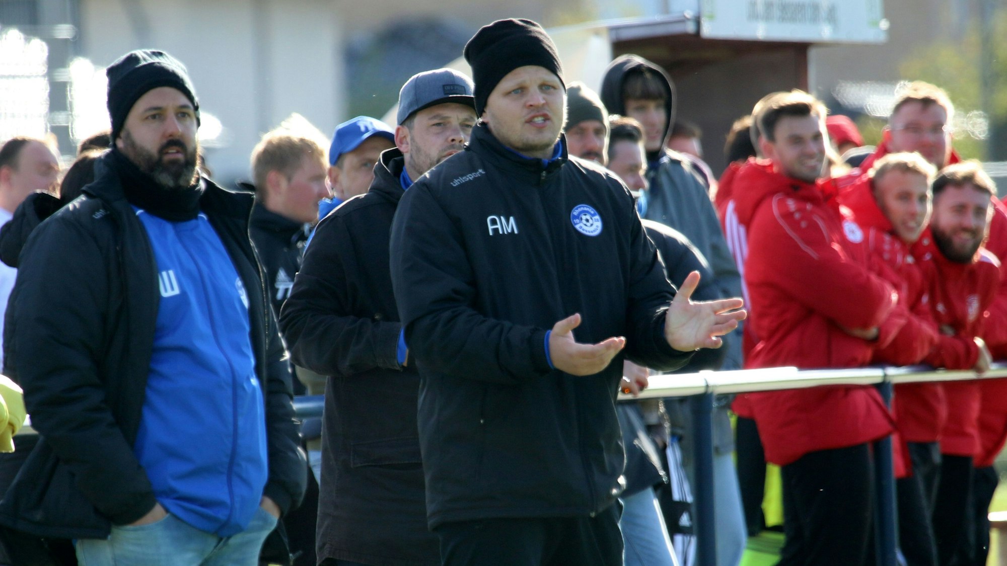 Artur Mezler steht während einer Fußballpartie am Spielfeldrand, hinter ihm Zuschauer.