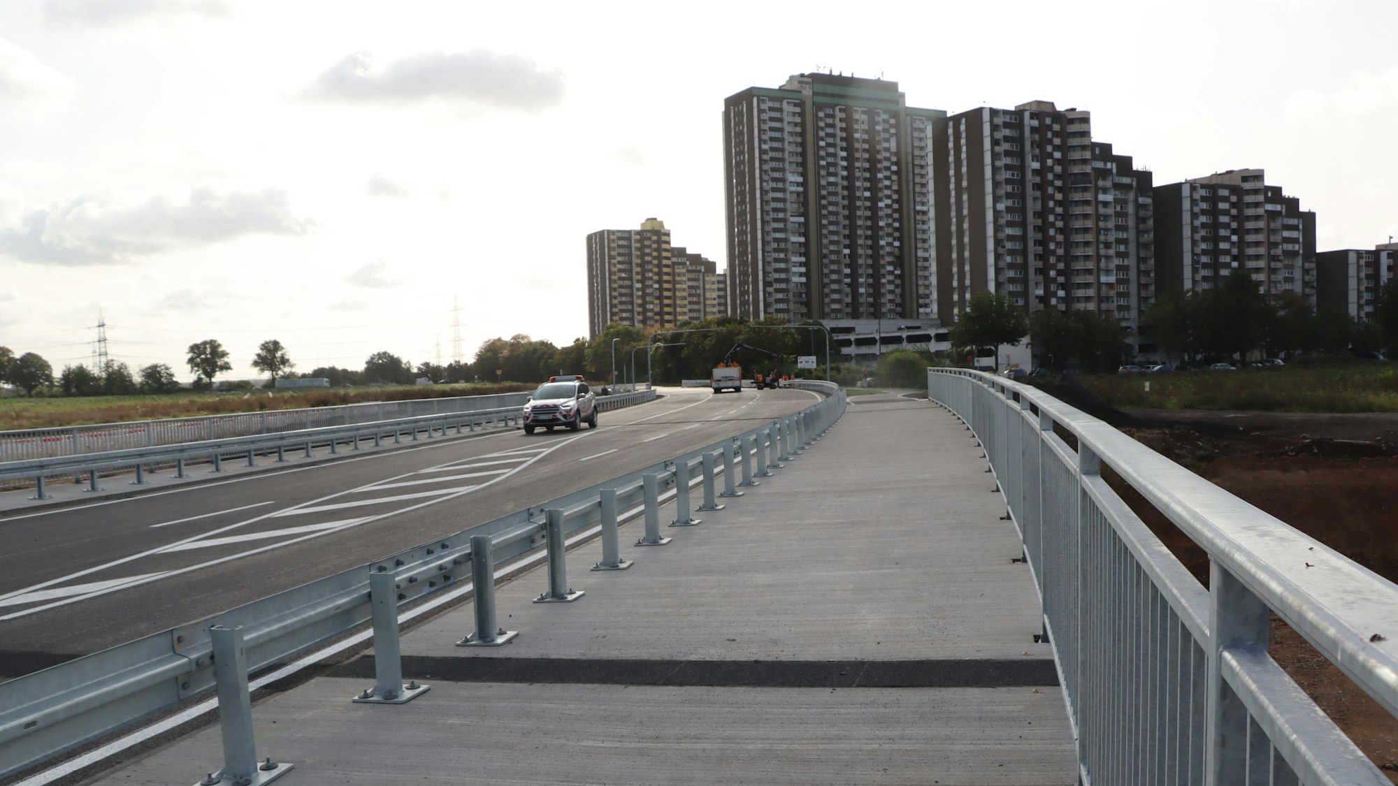 Zu sehen ist die neue Brücke und im Hintergrund die Hochhaussiedlung Kölnberg.