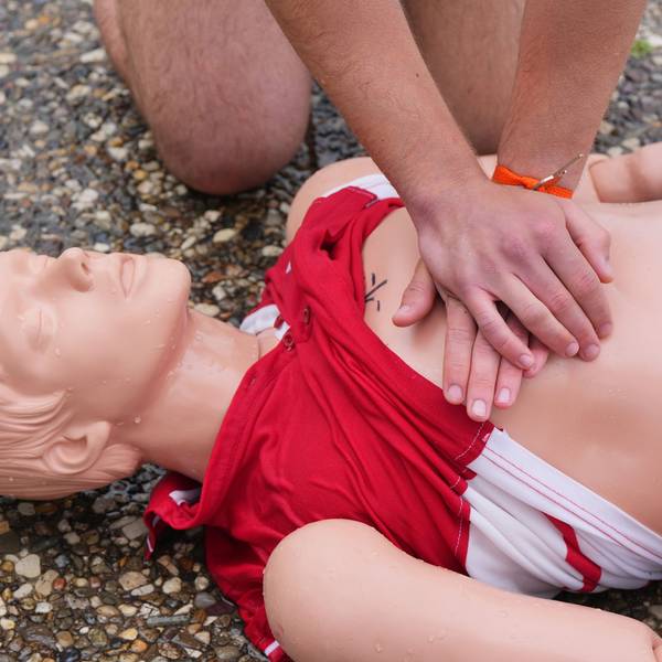Eine Person übt die Herzdruckmassage an einer Erste-Hilfe-Puppe.