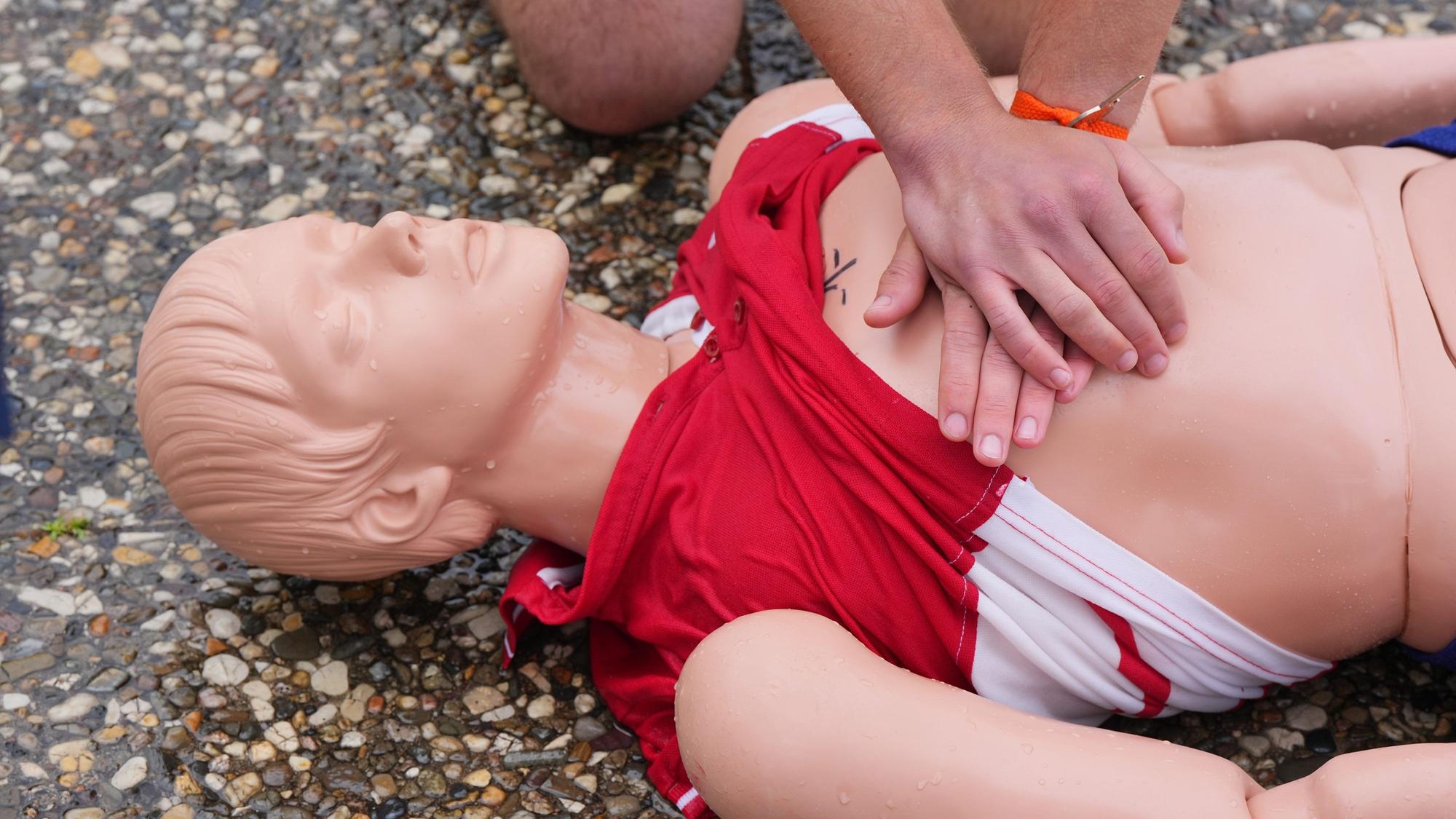 Eine Person übt die Herzdruckmassage an einer Erste-Hilfe-Puppe.
