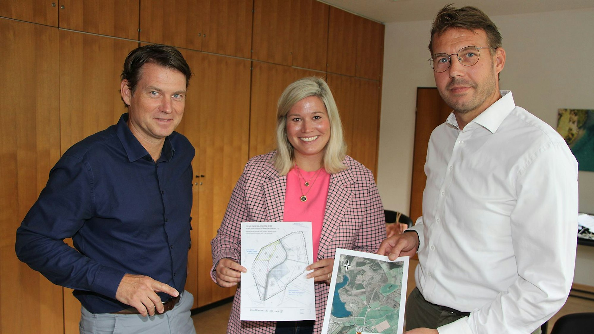 Die beiden Investoren und Bürgermeisterin Jennifer Meuren mit den Plänen für die am Freilinger See geplante Anlage.