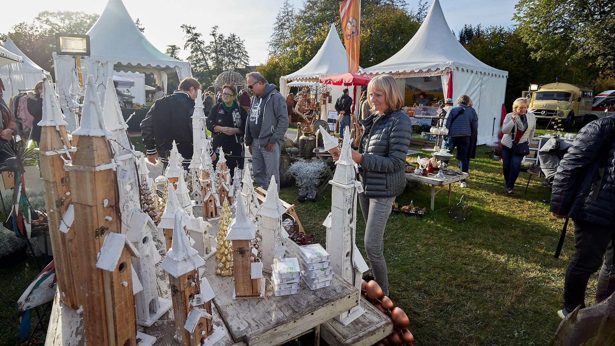 Besucher der Winterträume auf Schloss Eicks. Im Hintergrund stehen mehrere weiße Ausstellungspavillons.