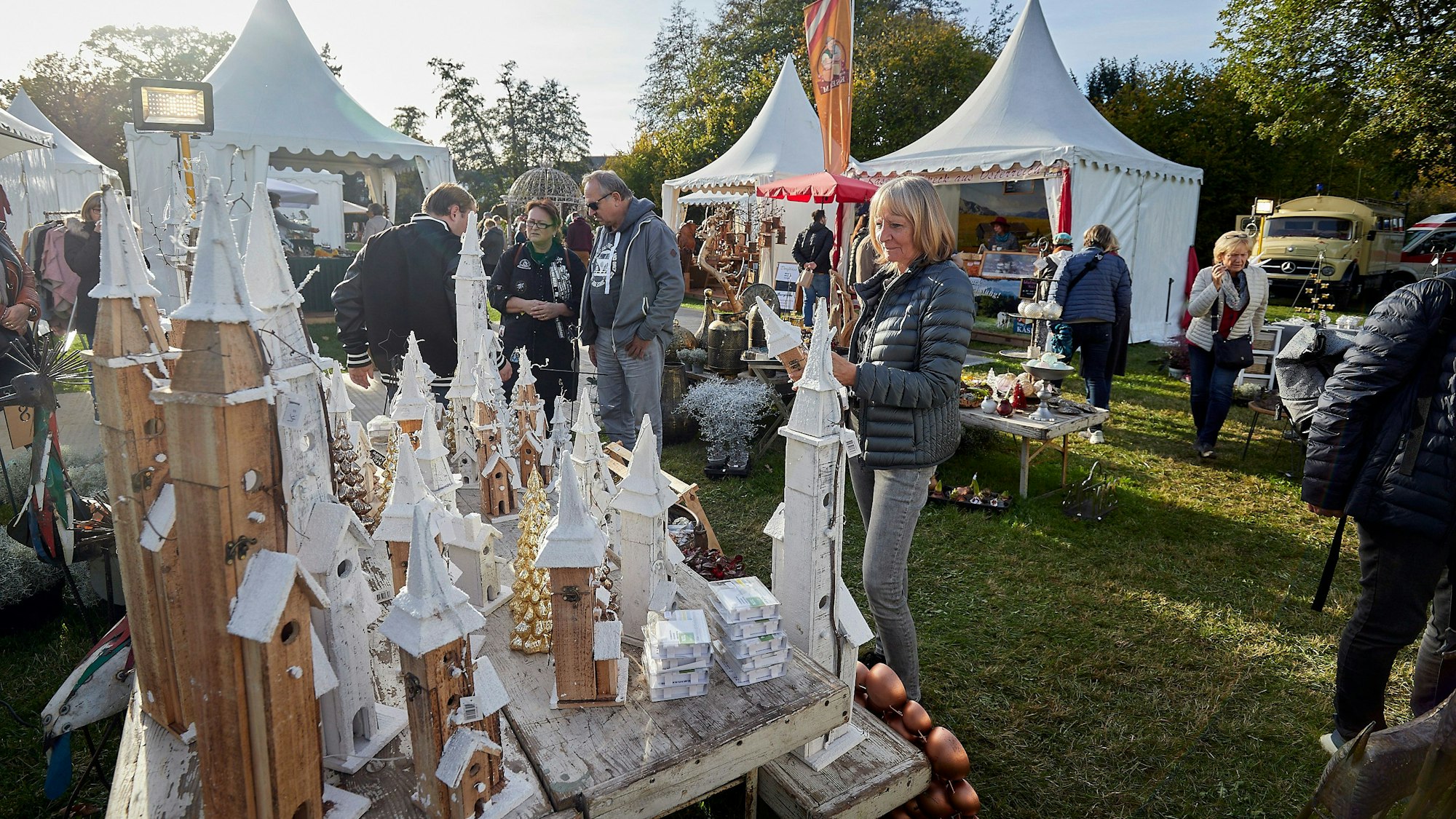 Besucher der Winterträume auf Schloss Eicks. Im Hintergrund stehen mehrere weiße Ausstellungspavillons.