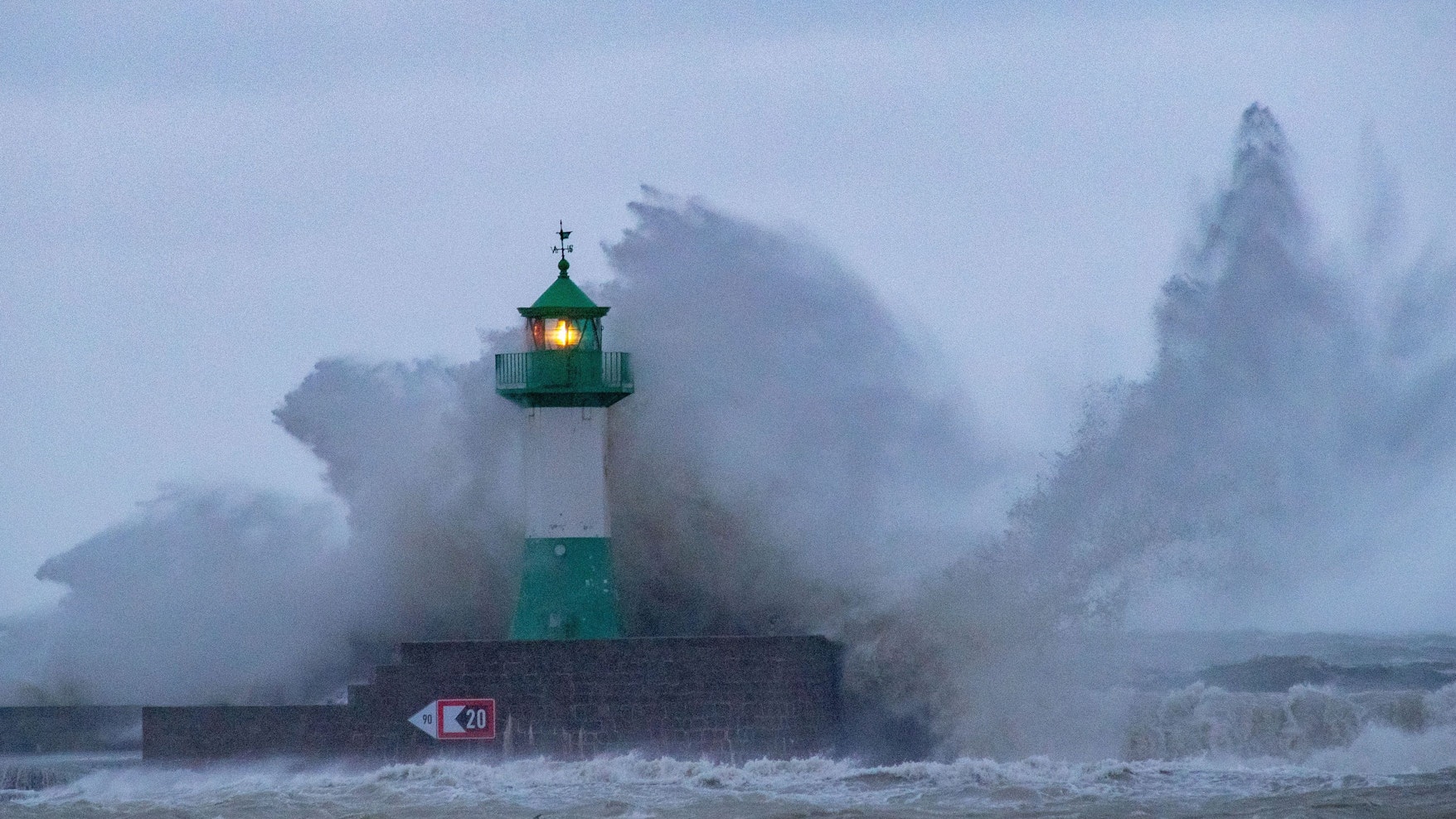 Riesenwellen schlagen über den Leuchtturm in Sassnitz. Wegen eines Sturmtiefs sind an der Ostseeküste die ersten Straßen und Uferbereiche vom Hochwasser überschwemmt worden.