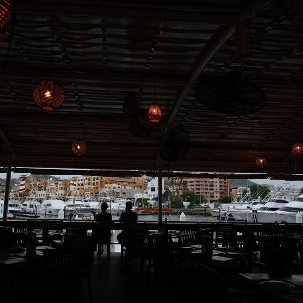 Ein Touristenpaar nimmt einen Drink in einer noch geöffneten Bar am Hafen von Cabo San Lucas.