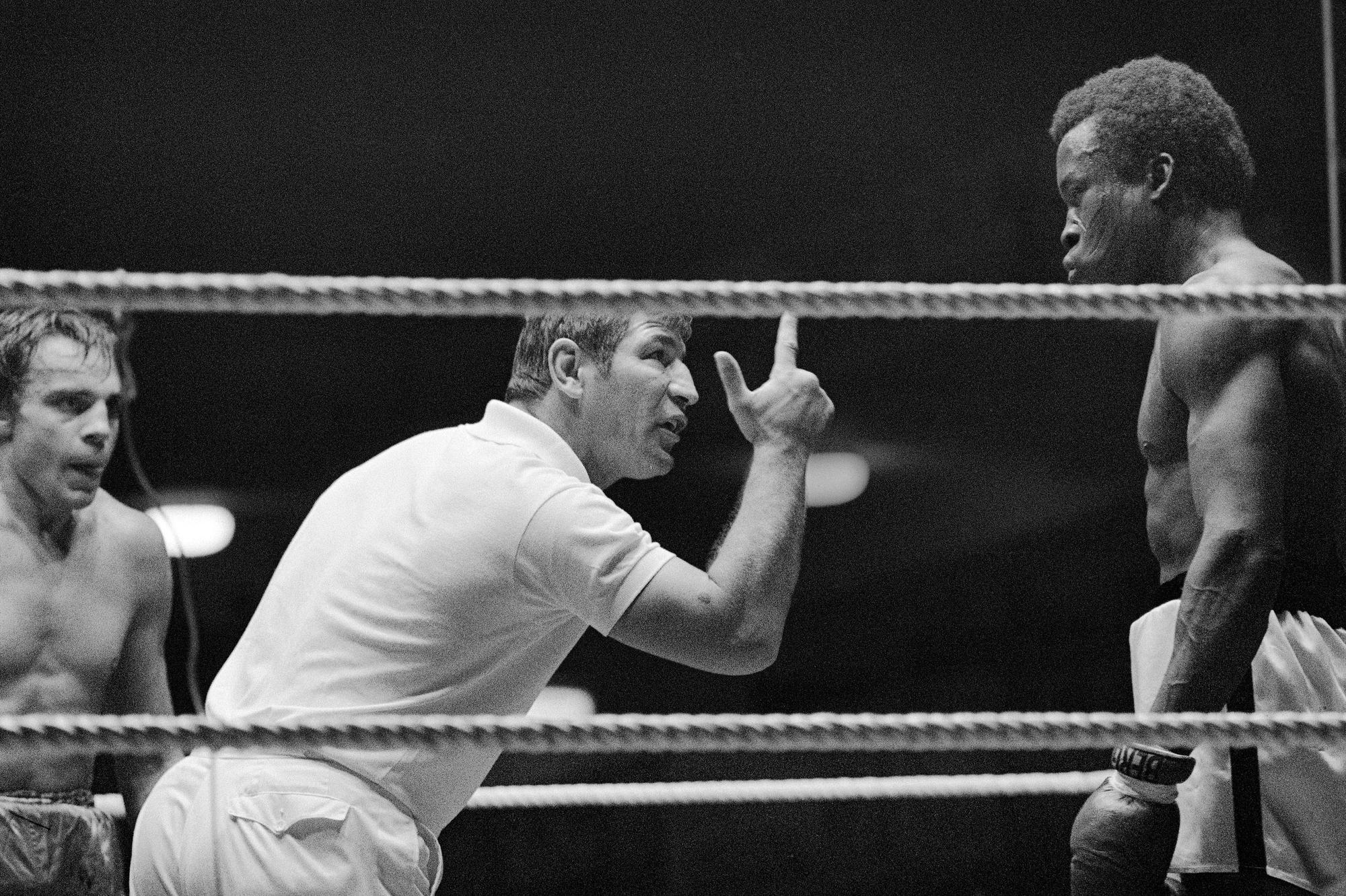Der Boxer Peter Müller (M.) als Ringrichter bei einem Boxkampf.