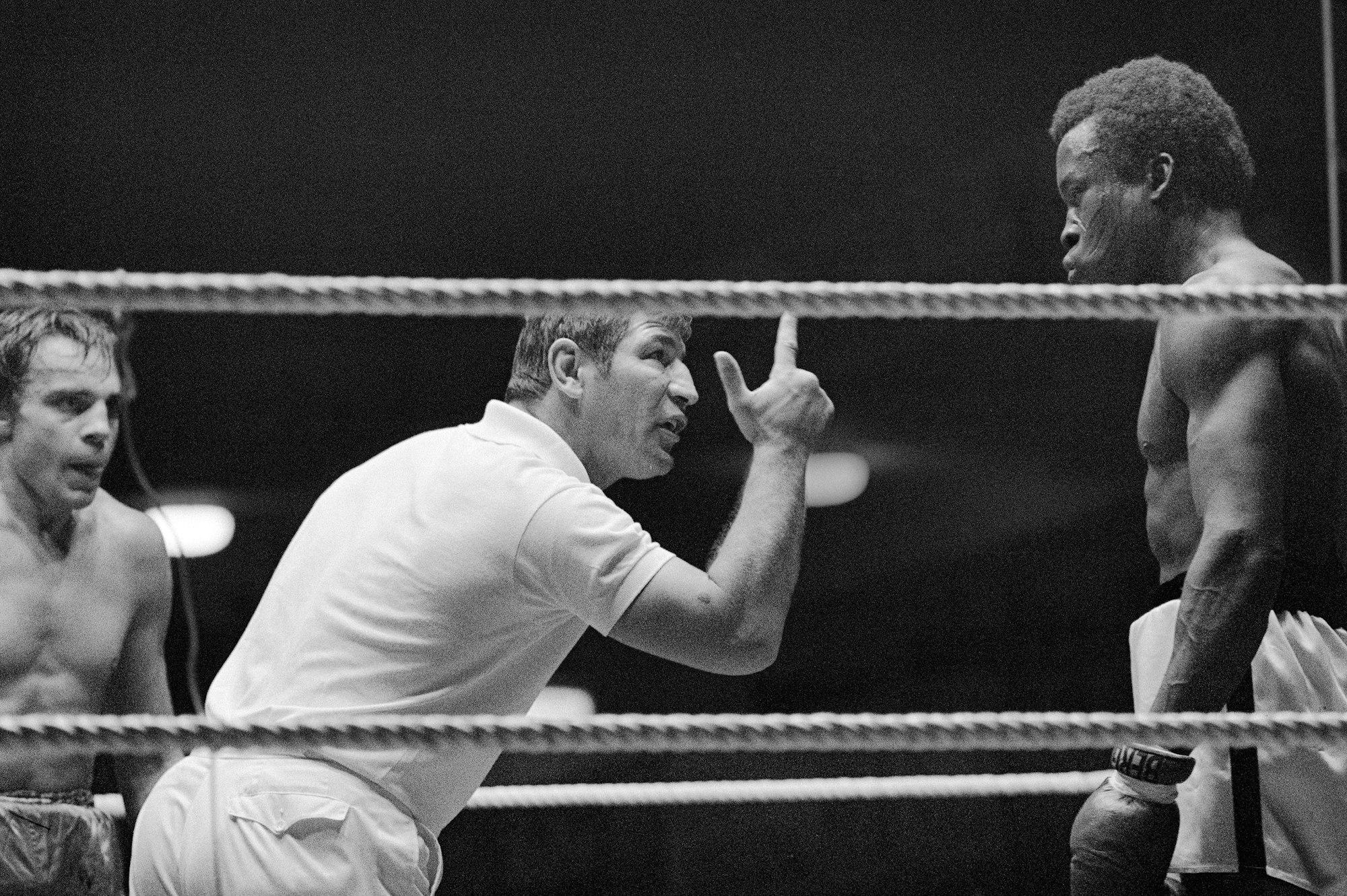 Der Boxer Peter Müller (M.) als Ringrichter bei einem Boxkampf.