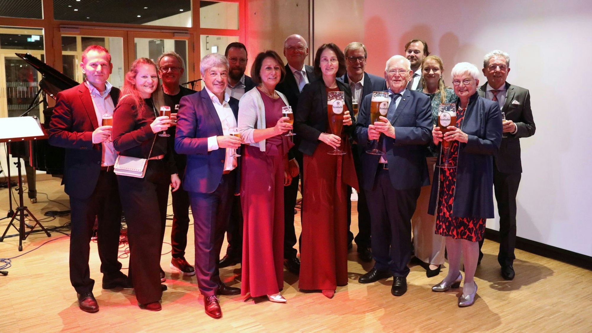Festlich gekleidete Menschen mit großen und kleinen Biergläsern.
