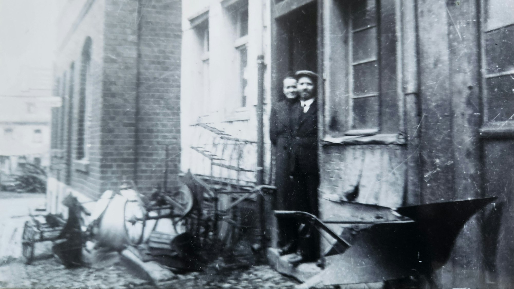 Auf einer alten Schwarz-weiß-Aufnahme steht ein Paar in der Tür einer Schmiede in Blumenthal.