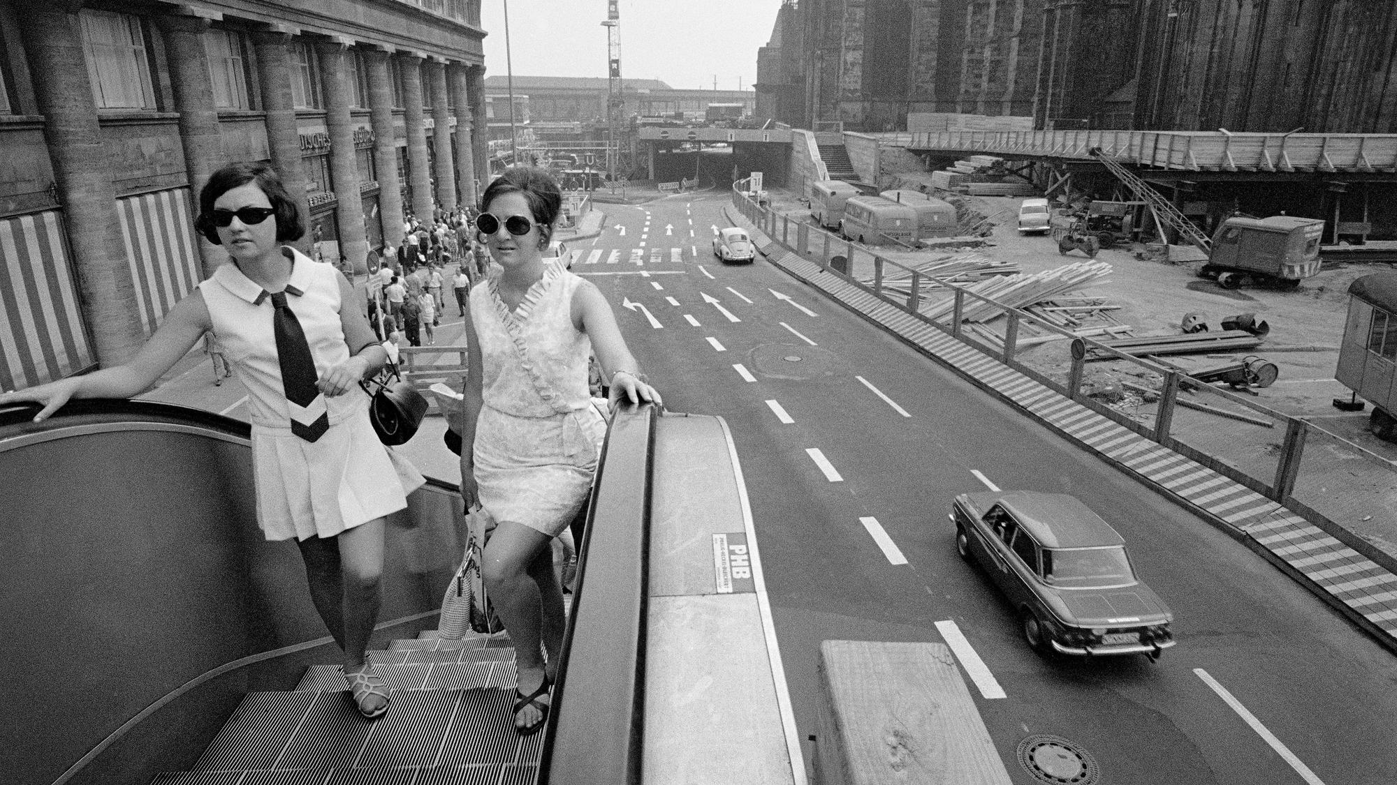 Als an der Trankgasse noch eine Rolltreppe stand: Stilvoll überqueren diese Damen um 1970 die Straße an der Baustelle Domplatte.
