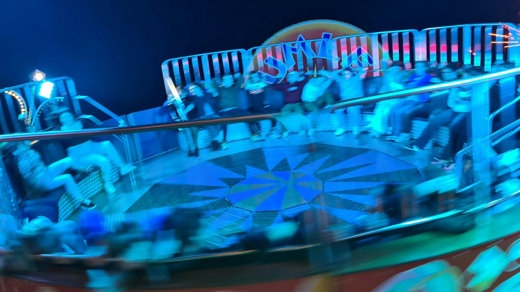 Das Foto zeigt Kirmesbesucher auf einem rotierenden Fahrgeschäft.