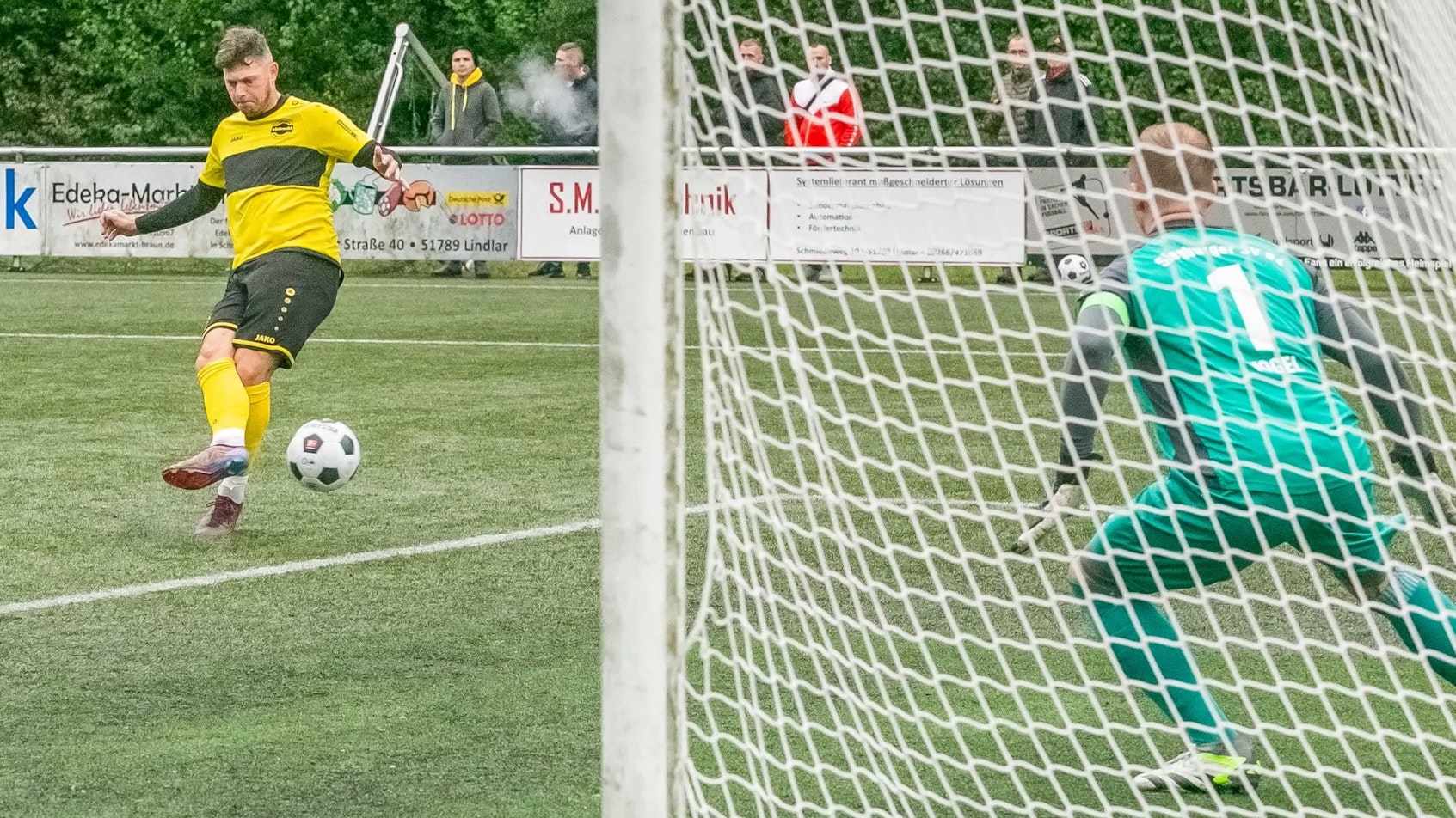 Ein Hohkeppeler Fußballer läuft mit dem Ball am Fuß auf den Siegburger Torwart zu.