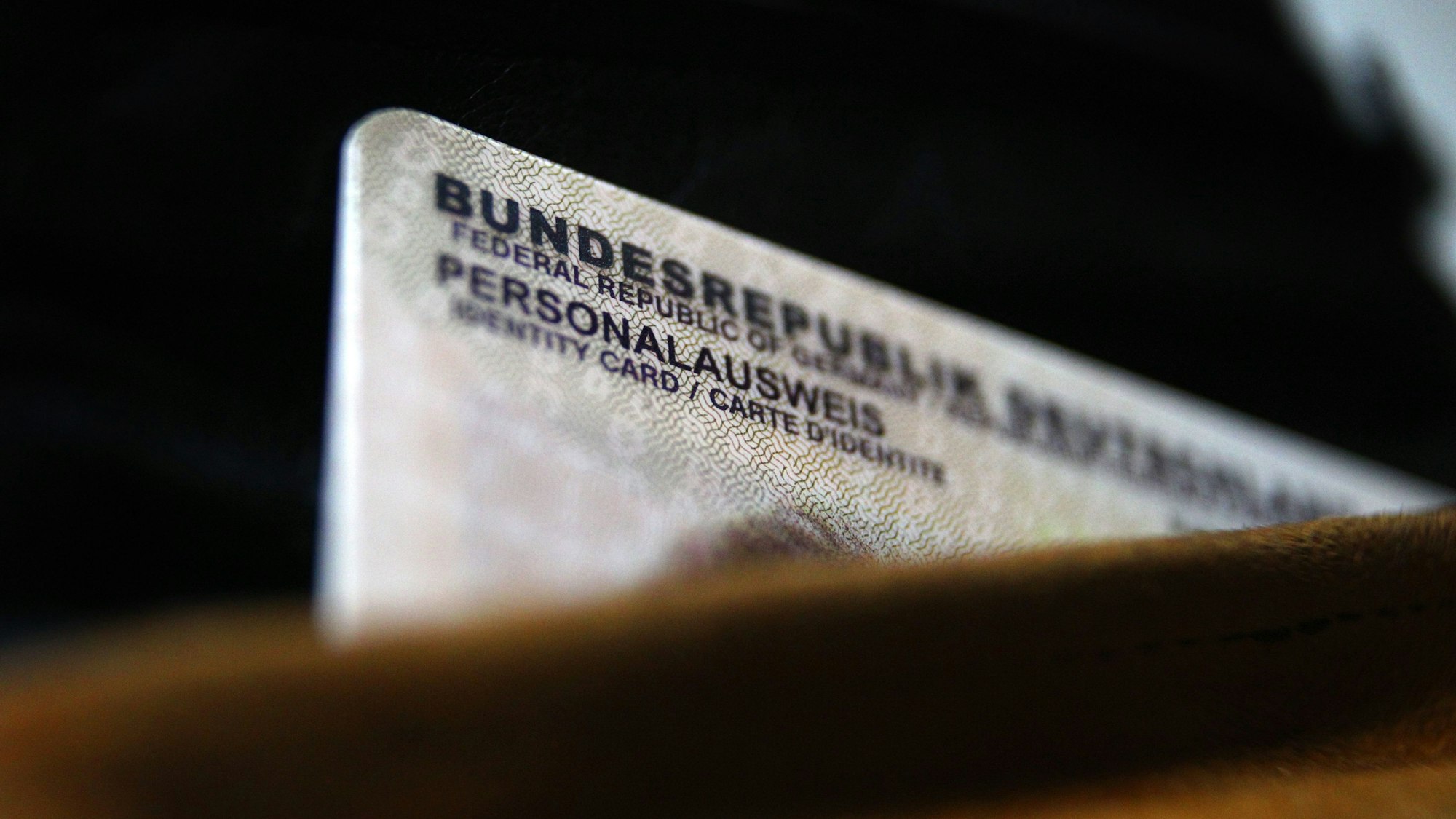 ARCHIV - 26.09.2014, Bayern, Kaufbeuren: Ein deutscher Personalausweis ragt aus einer Geldbörse.