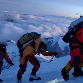 ARCHIV - 01.10.2023, China, Berg Cho Oyu: Mitglieder eines chinesischen Expeditionsteams steigen in einer Seilschaft auf den Gipfel des Berg Cho Oyu, der auch als Qowowuyag bekannt ist, im Himalaya.