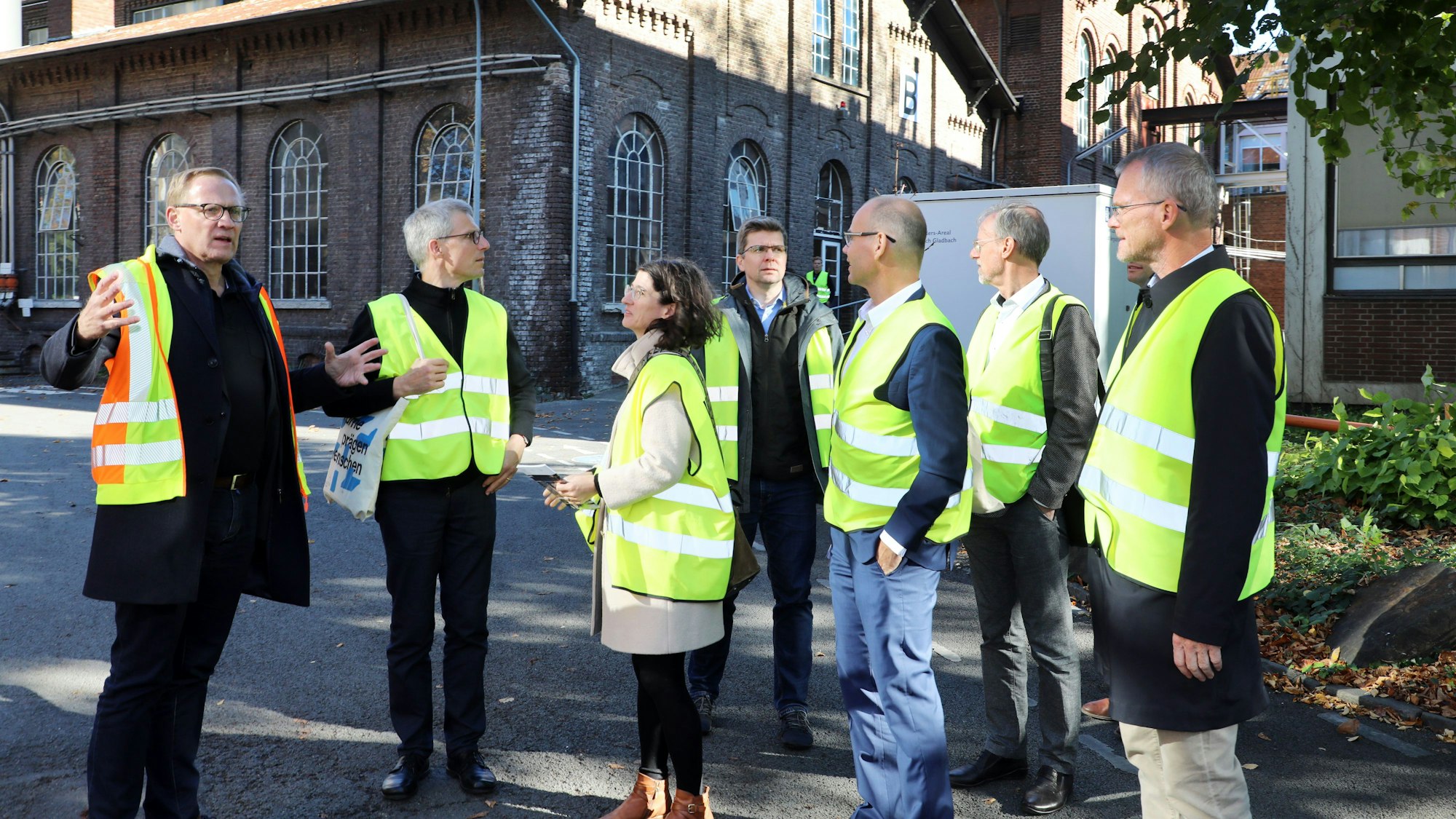 Die Gäste stehen in Warnwesten auf dem Zanders-Areal.
