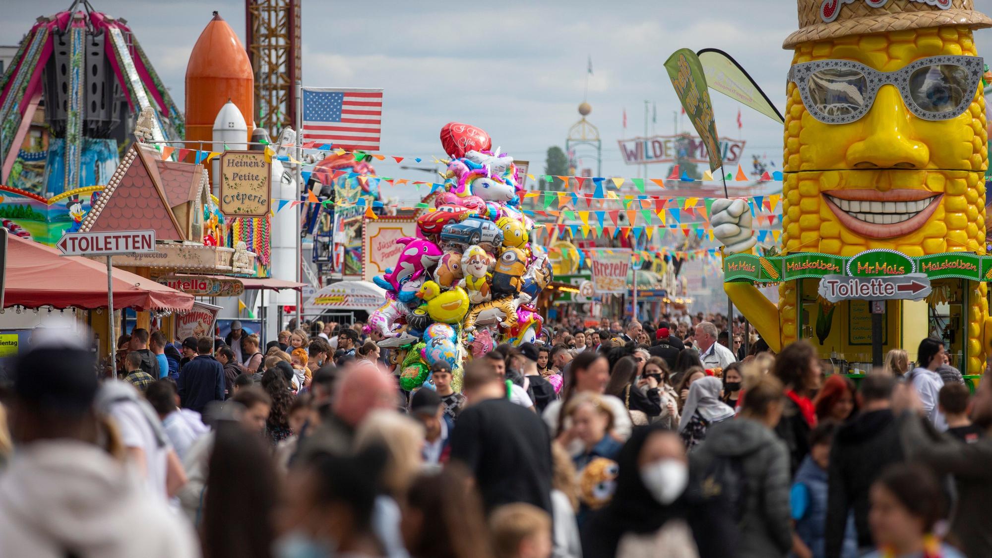 Viele Menschen laufen durch einen Hauptgang der Kirmes.