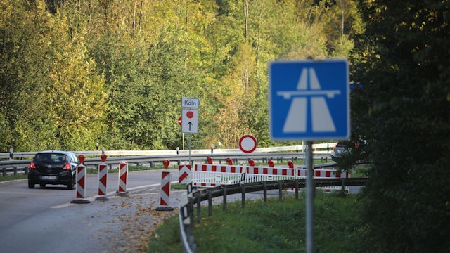Zu sehen ist ein Auto, das an einer Straßensperrung vorbeifährt.