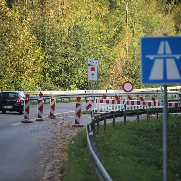Zu sehen ist ein Auto, das an einer Straßensperrung vorbeifährt.